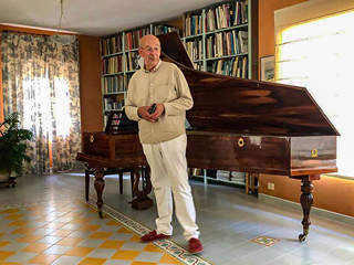 Photo de Michel Chaillan devant le piano Pleyel de 1830