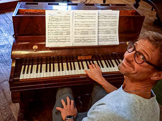 Photo d’Edoardo Torbianelli au clavier du pianino Pleyel